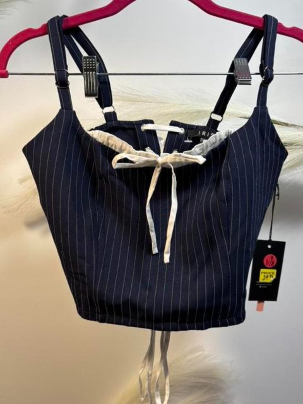 navy pinstripe corset top with white ribbon bow detail and adjustable straps.